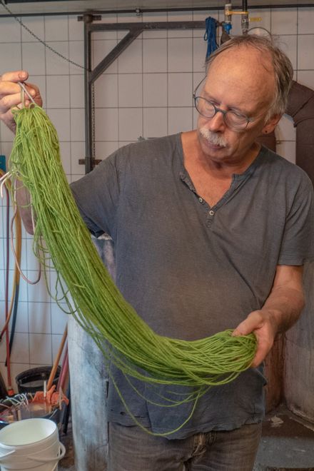 Dieter Kaiser hält einen grün gefärbten Wollstrang · aus „Farbenrausch“